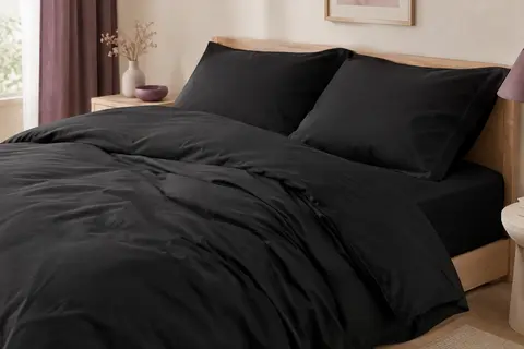 Parure de lit noire en microfibre brossée, avec housse de couette et deux taies sur un lit