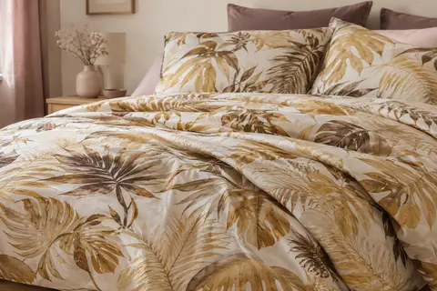 Parure de lit en microfibre à motif jungle doré, avec housse de couette et deux taies sur un lit.