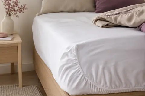 Protège-matelas blanc en coton mélangé ajusté sur un matelas, avec coin élastiqué en microfibre