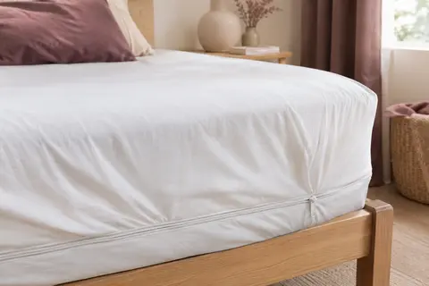 Housse intégrale blanche en jersey installée sur un matelas, avec sa fermeture à glissière latérale visible.