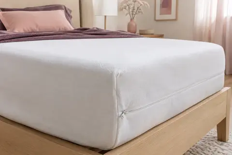 Housse intégrale blanche posée sur un matelas, avec sa fermeture éclair visible sur le côté.